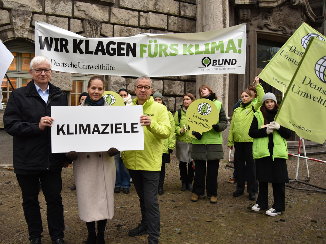 Menschen halten Schild mit der Beschriftung Klimaziele